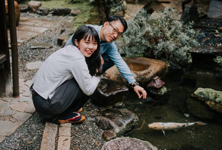 Young japanese couple spending time in their koi pond