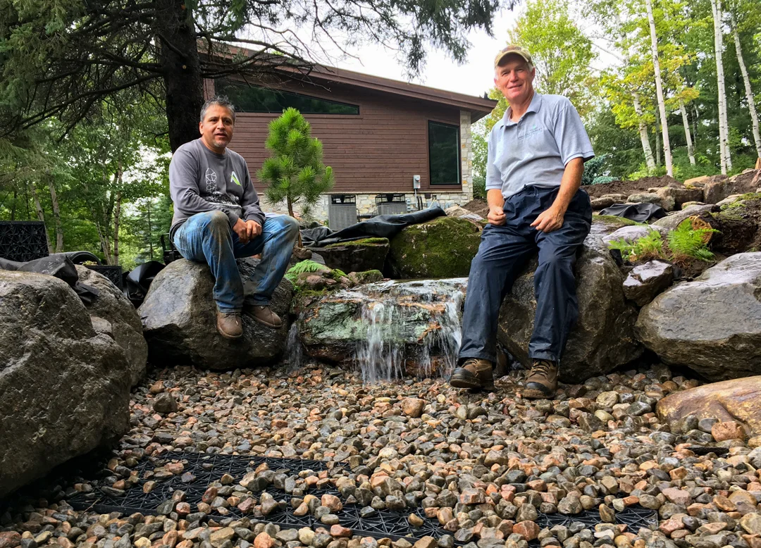 Certified Aquascape Contractors finishing a large pond
