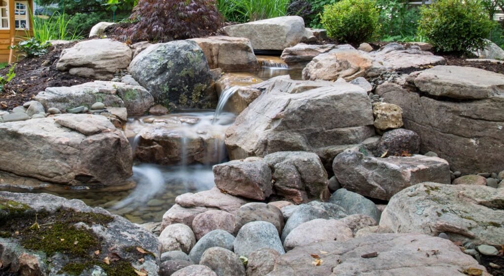 A window of tranquility with custom aquascape pond and beautifully place boulder for a big statement